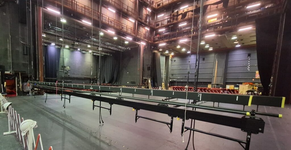 Image of the empty stage, from the wings. Part of the flying system is visible