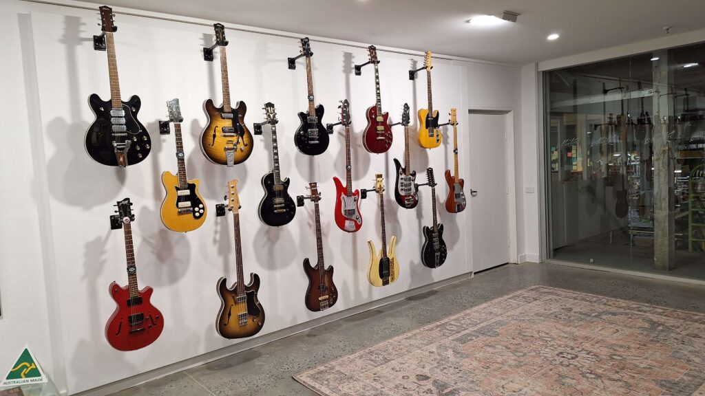 A wall display of many historic and classic guitar models